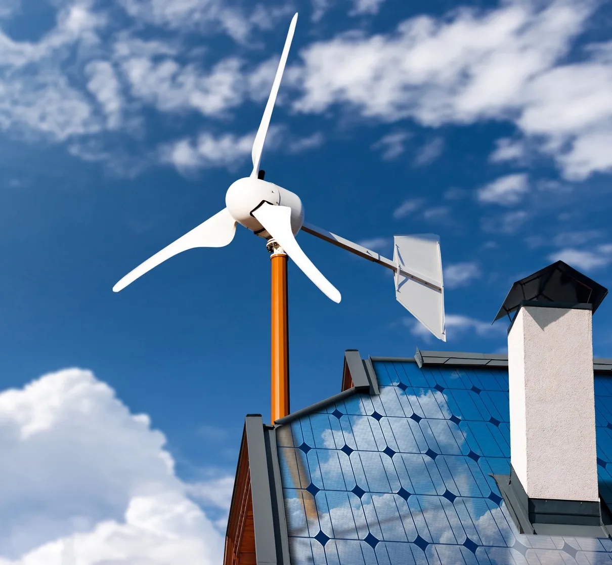 Kleinwindanlage auf einem Hausdach mit Solarpanels